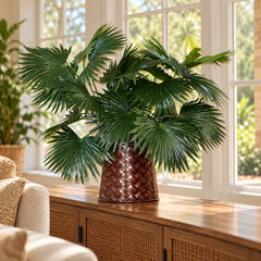 22-inch artificial Chinese fan palm arrangement in its basketweave metal container on a sunroom sideboard.