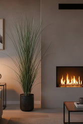 71 inch Artificial PVC Grass Plant is in a decorative container flanking the side of a fireplace.