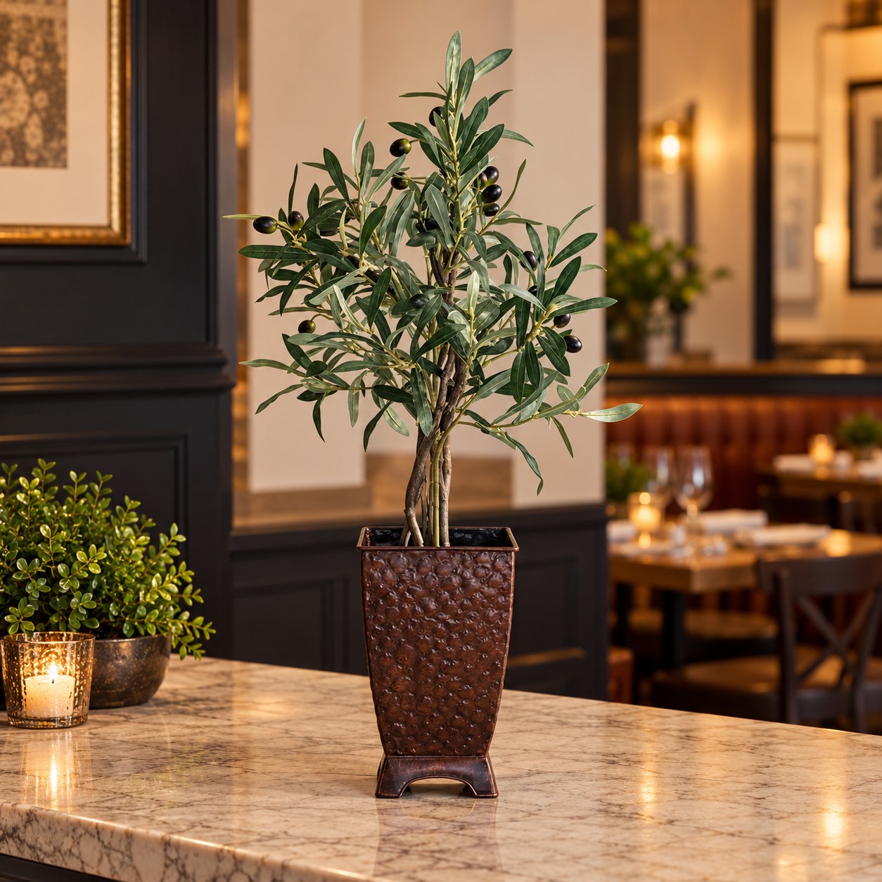28 inch artificial olive tree on natural wood in a hammered copper container on a restaurant host counter