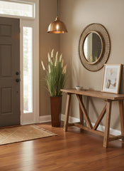 Artificial cattail grass arrangement with 16 blooms in faux leather metal floor vase placed in the corner of an indoor front entryway.