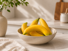 set of 4 artificial bananas in a decorative bowl as a centerpiece for a kitchen table